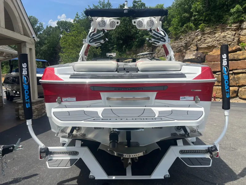 Slide: The Image of 2022 Centurion Ri230 boat, red and white, rear view, parked outdoors. - 6