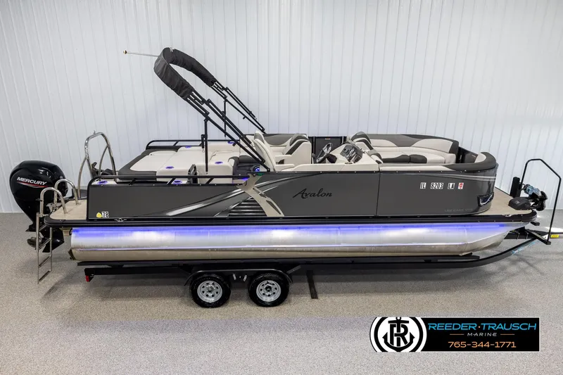 Slide: The Image of 2021 Avalon LSZ VRB pontoon boat on trailer, side view, in showroom setting. - 0