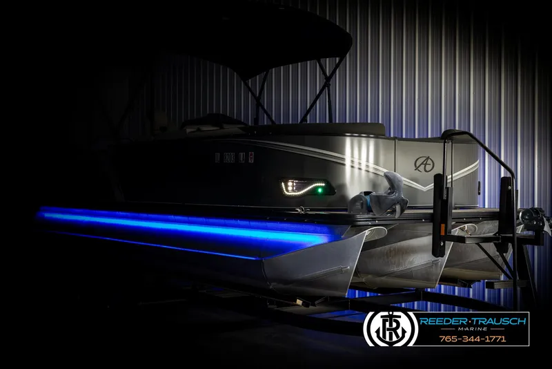 Slide: The Image of 2021 Avalon LSZ VRB pontoon boat with blue LED lights in a dimly lit setting. - 3