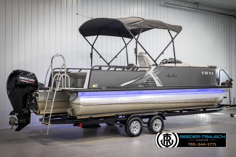 Slide: The Image of 2021 Avalon LSZ VRB pontoon boat with canopy on trailer, displayed indoors. - 5