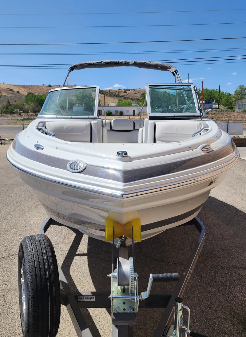Slide: The Image of 2024 Crownline 200SS boat on trailer, front view, sunny day. - 3