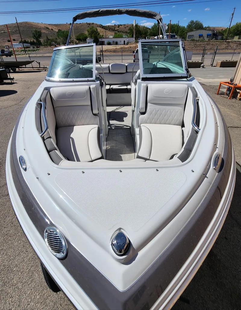 Slide: The Image of 2024 Crownline 200SS boat with open bow seating, docked outdoors. - 4