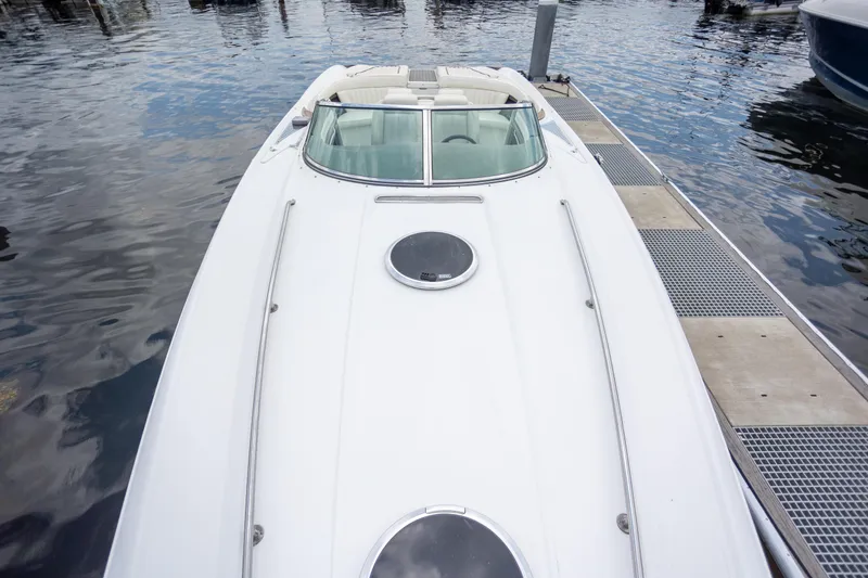 Slide: The Image of 2005 Cobalt 343 boat docked, showcasing sleek white design and spacious deck. - 28