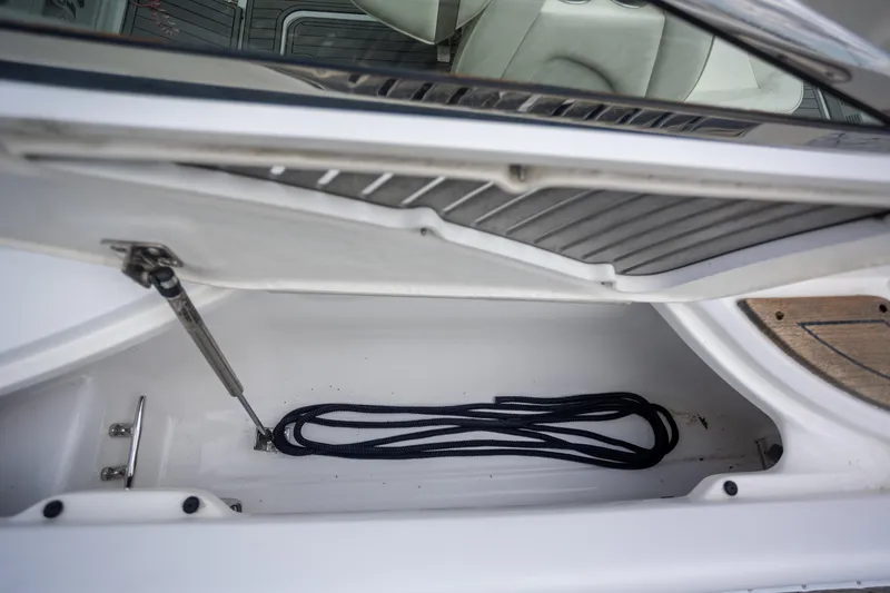 Slide: The Image of Open storage compartment on 2005 Cobalt 343 boat with coiled rope inside. - 29