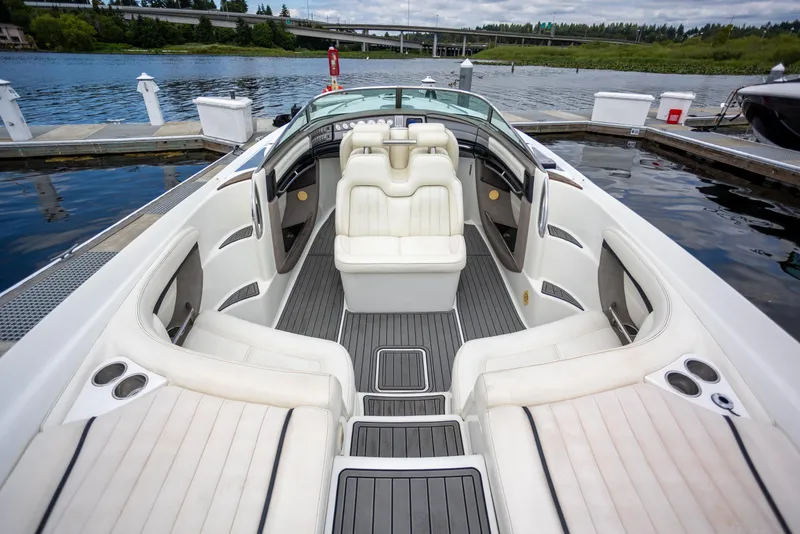 Slide: The Image of 2005 Cobalt 343 boat interior with white seating, docked by a serene lake. - 3