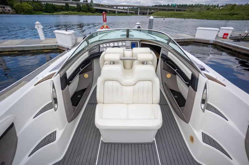 Slide: The Image of 2005 Cobalt 343 boat interior with white seating, docked by a scenic waterfront. - 8
