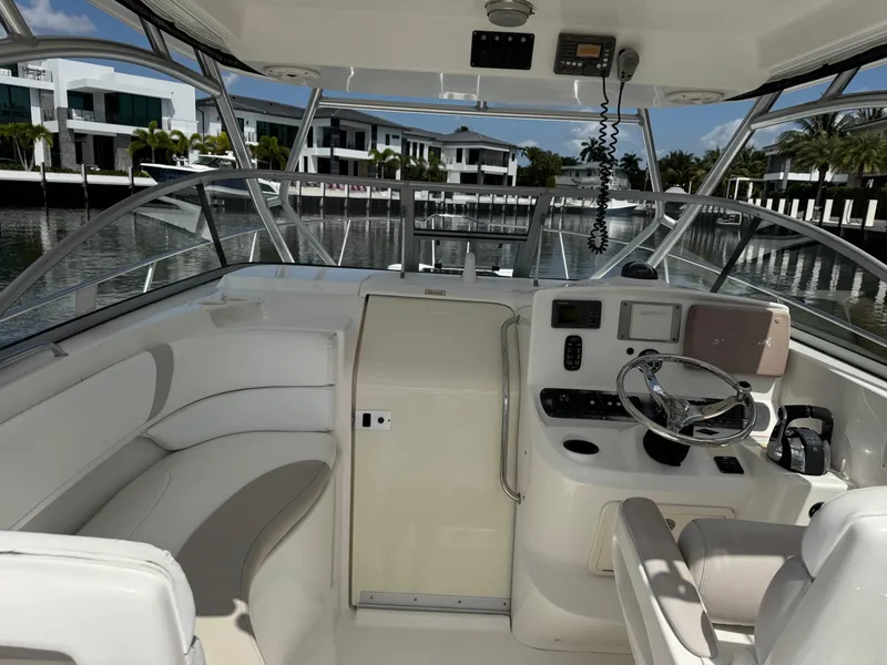 Slide: The Image of 2006 Boston Whaler 305 Conquest cockpit with steering wheel, seating, and navigation equipment. - 19