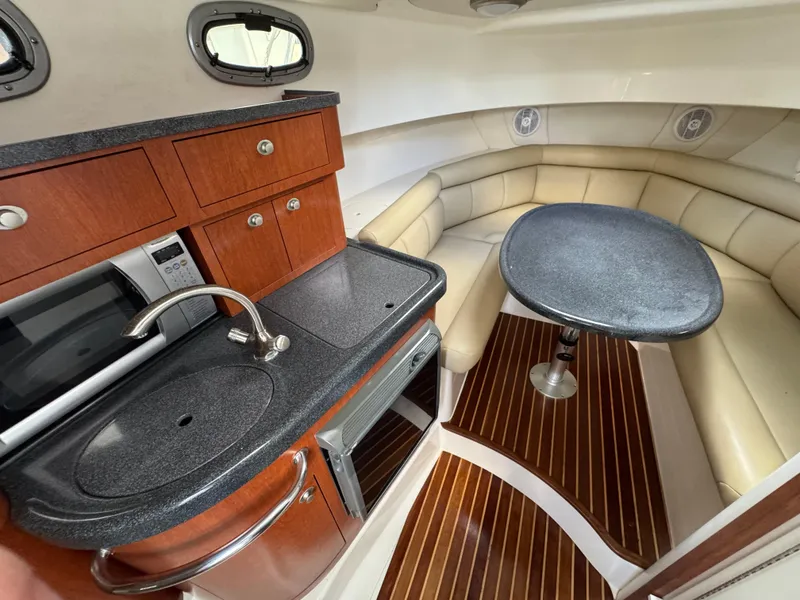 Slide: The Image of 2006 Boston Whaler 305 Conquest cabin with kitchenette and seating area. - 20