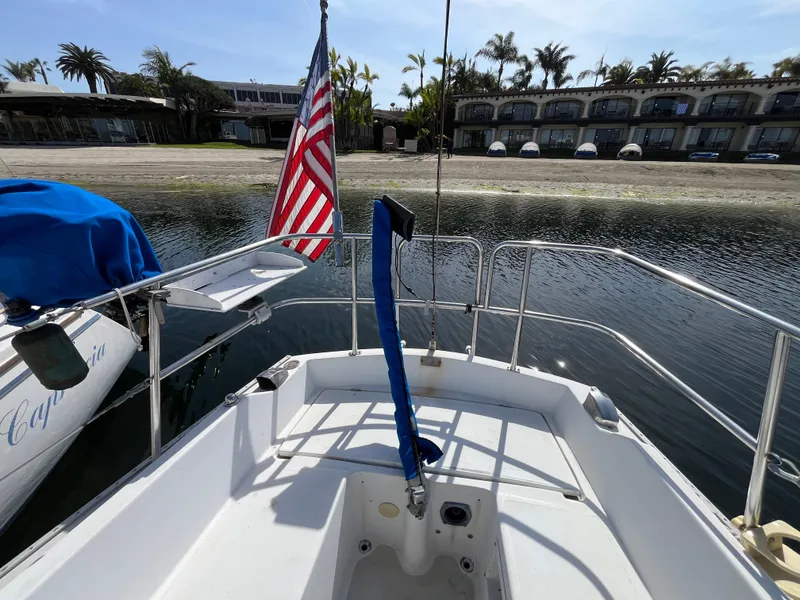 Slide: The Image of 1982 Catalina 27 sailboat with American flag docked near waterfront buildings. - 10
