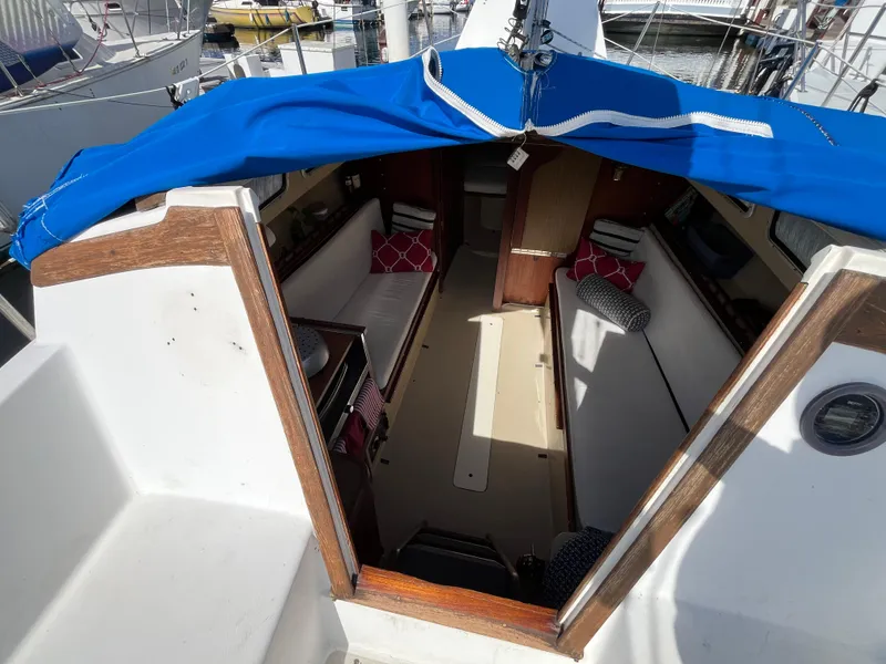 Slide: The Image of Interior view of a 1982 Catalina 27 sailboat with blue cover and cozy seating. - 12