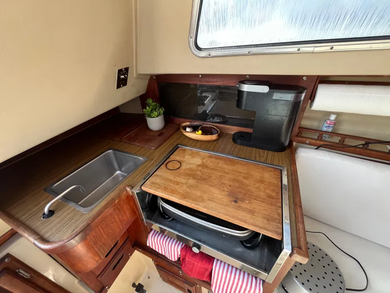 Slide: The Image of Compact kitchen area in a 1982 Catalina 27 sailboat with sink and wooden countertop. - 16