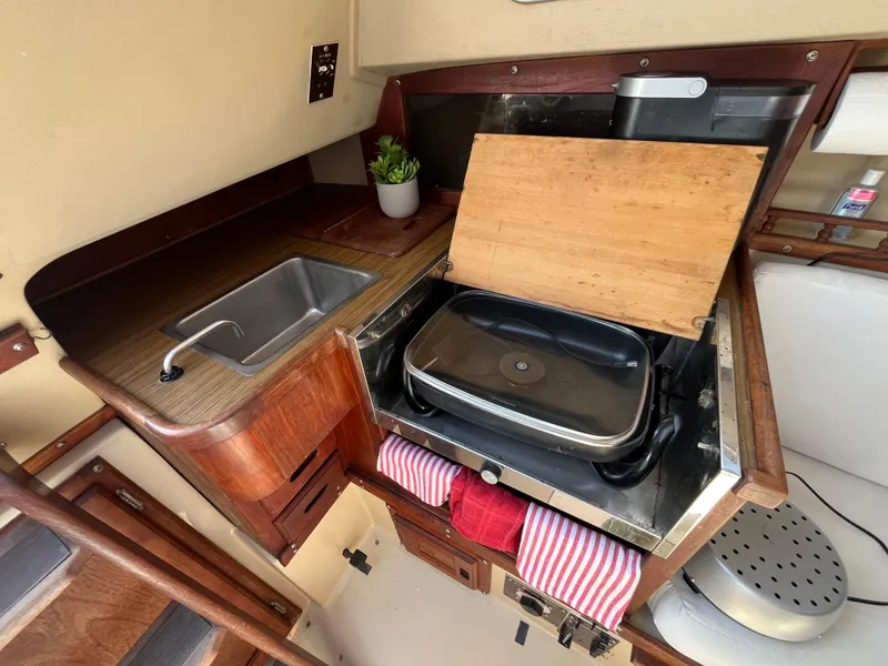 Slide: The Image of Compact kitchen area in a 1982 Catalina 27 sailboat with stove and sink. - 17