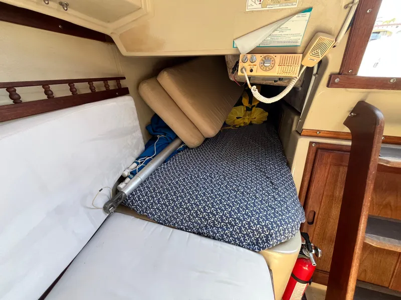 Slide: The Image of Interior cabin of a 1982 Catalina 27 sailboat with cozy bedding and storage. - 18