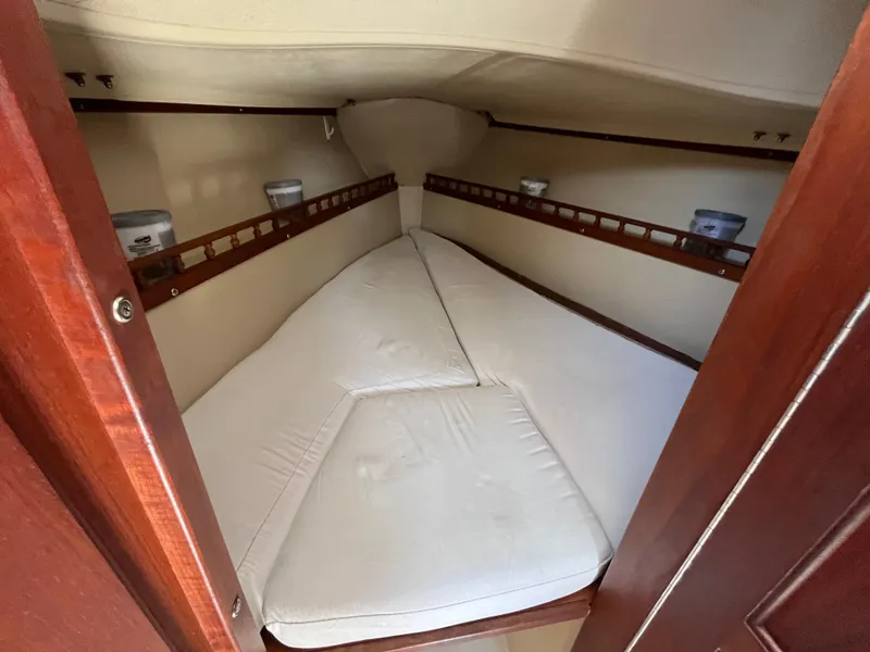 Slide: The Image of 1982 Catalina 27 sailboat interior cabin with V-berth and white cushions. - 20