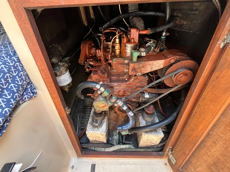 Slide: The Image of Engine compartment of a 1982 Catalina 27 sailboat, showing detailed mechanical components. - 27