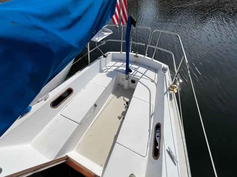 Slide: The Image of 1982 Catalina 27 sailboat deck with blue cover and American flag. - 7