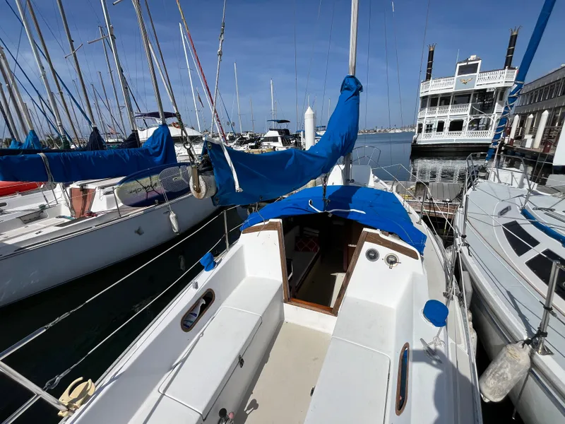 Slide: The Image of 1982 Catalina 27 sailboat docked in marina, blue covers, clear sky. - 8