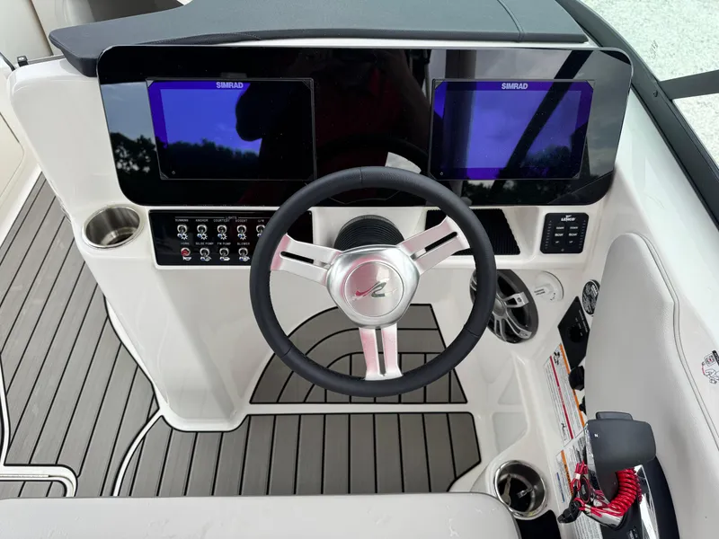 Slide: The Image of 2025 Sea Ray SDX 250 helm with dual Simrad displays and modern steering wheel. - 15