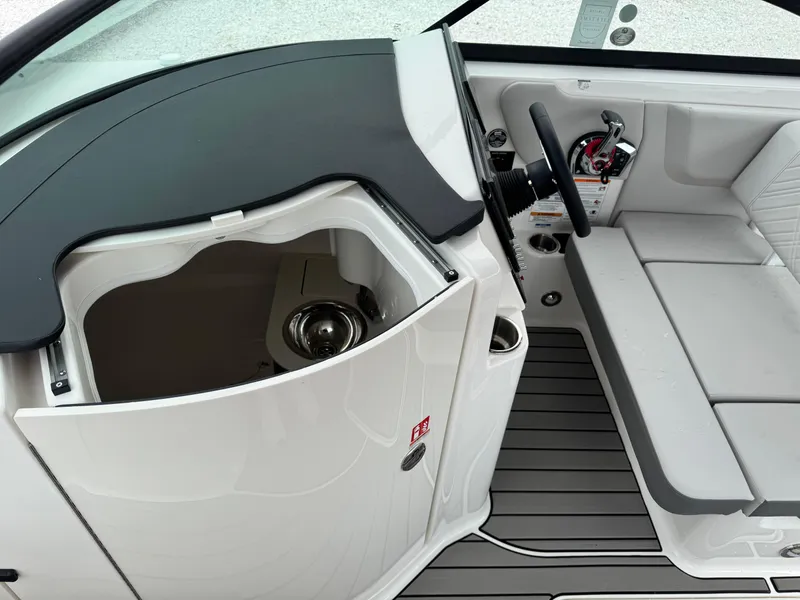 Slide: The Image of 2025 Sea Ray SDX 250 boat interior with helm, seating, and storage compartment. - 19