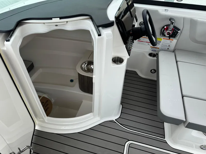 Slide: The Image of 2025 Sea Ray SDX 250 boat interior with helm, seating, and compact cabin space. - 20