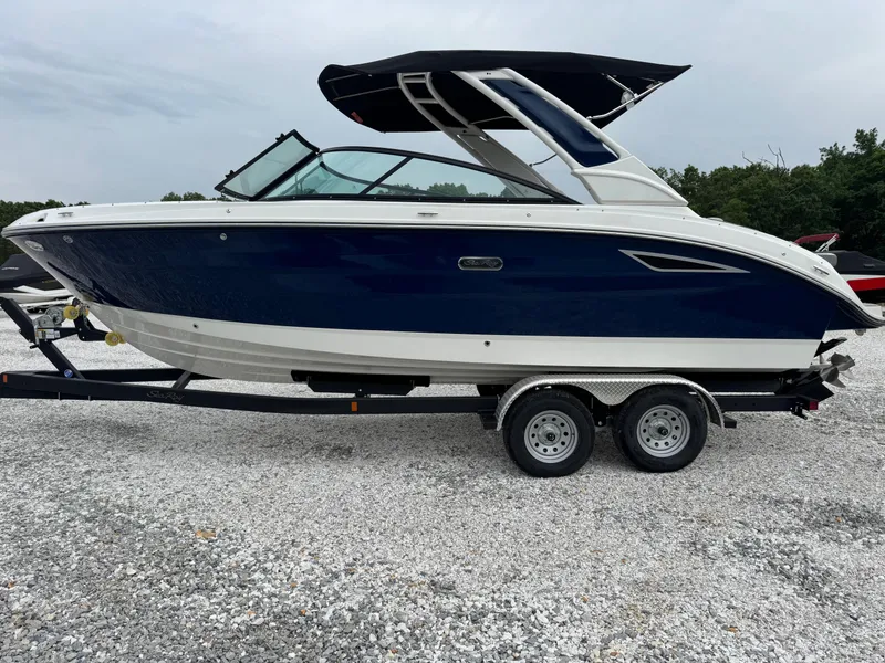 Slide: The Image of 2025 Sea Ray SDX 250 boat on trailer, blue and white design, parked on gravel. - 5