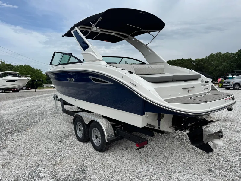 Slide: The Image of 2025 Sea Ray SDX 250 boat on trailer, blue and white design, parked outdoors. - 6