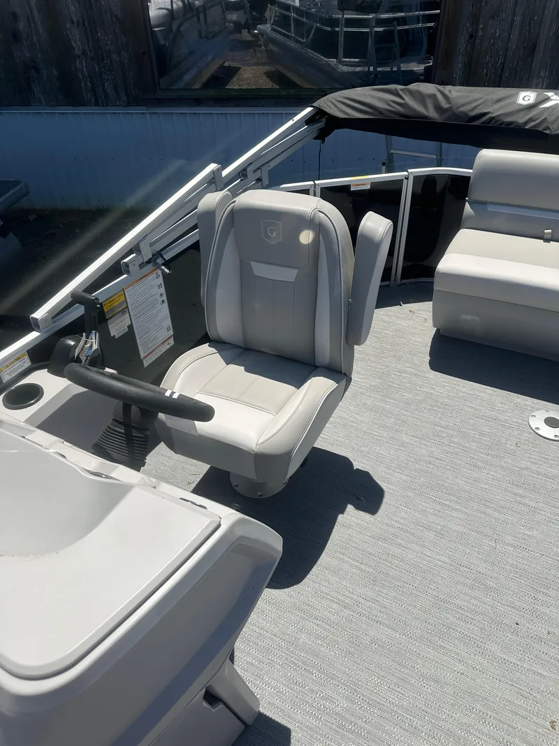 Slide: The Image of 2025 Godfrey 2086 CPX Sport-Tube Tritoon boat interior with captain's chair and seating. - 12