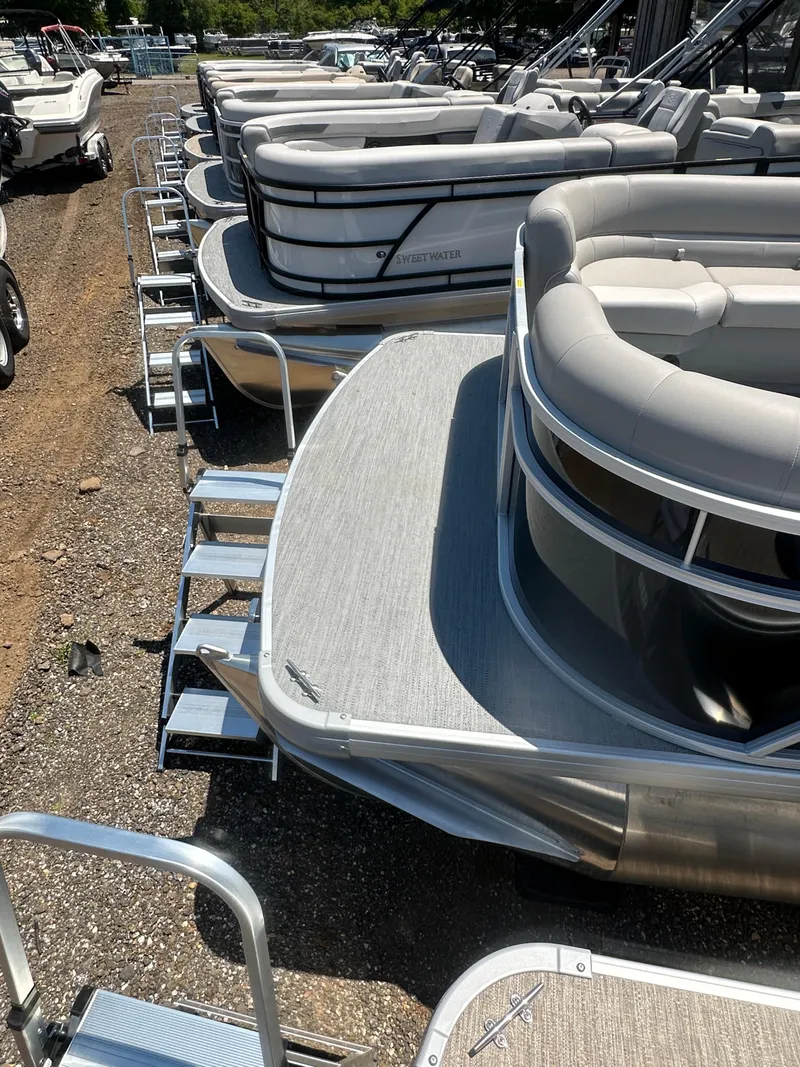 Slide: The Image of 2025 Godfrey 2086 CPX Sport-Tube Tritoon boats lined up in a marina. - 16