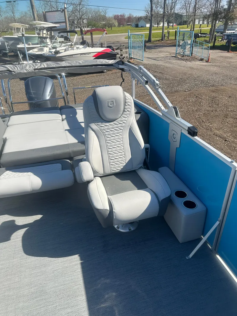 Slide: The Image of 2025 Godfrey Monaco 235 DFL Tritoon with luxurious seating and cup holders. - 18