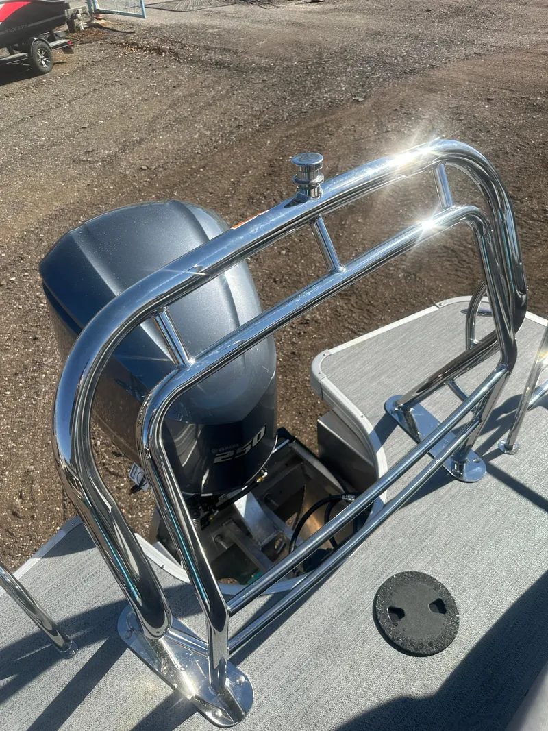 Slide: The Image of 2025 Godfrey Monaco 235 DFL Tritoon with shiny chrome railing and powerful outboard motor. - 27