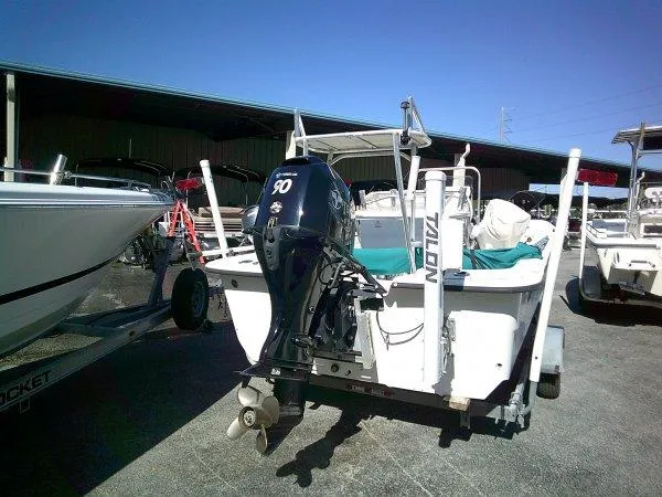 Slide: The Image of 2018 Carolina Skiff 198 DLX boat with outboard motor in a marina setting. - 6
