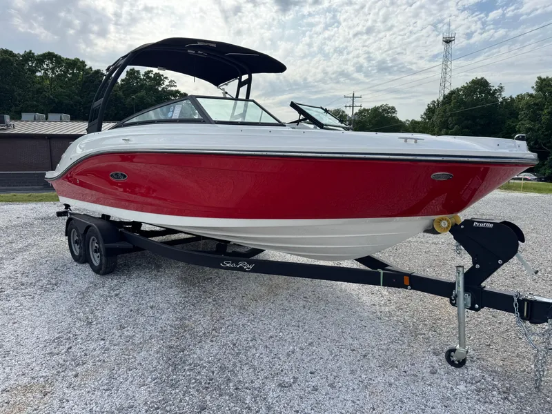 The Image of 2025 Sea Ray SPX 230 boat in red and white on a trailer, parked outdoors. - 1
