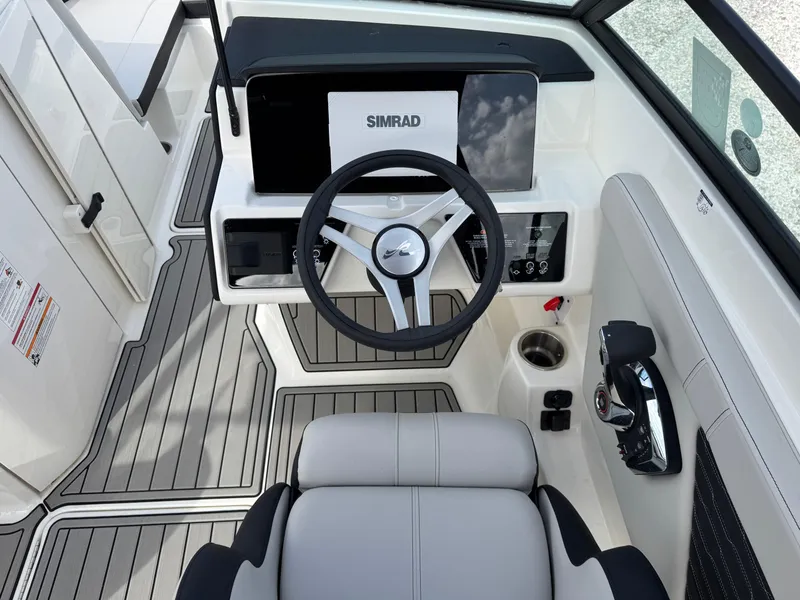 Slide: The Image of 2025 Sea Ray SPX 230 boat cockpit with Simrad display and modern steering wheel. - 12