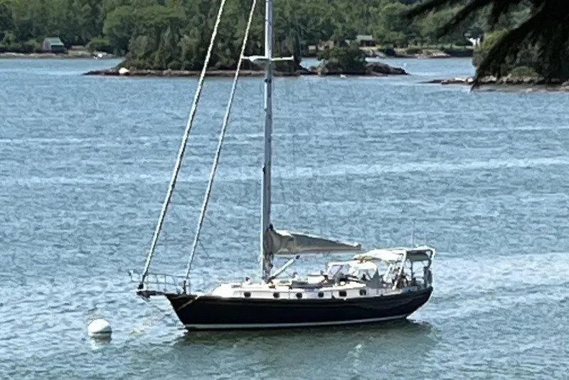 Slide: The Image of 1985 Shannon 43 Classic Cutter sailboat anchored in scenic waters. - 0