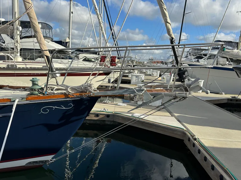 Slide: The Image of 1985 Shannon 43 Classic Cutter docked at marina, featuring elegant bow design and clear blue sky. - 11