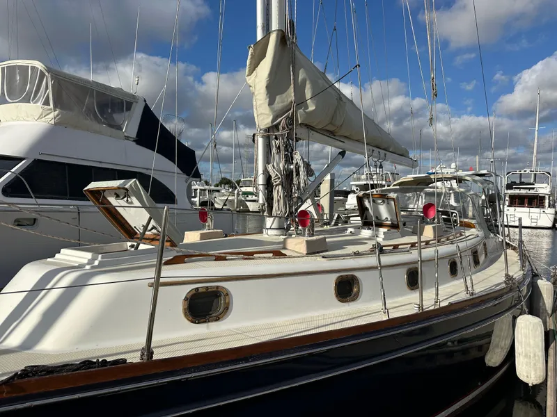 Slide: The Image of 1985 Shannon 43 Classic Cutter sailboat docked at marina under cloudy sky. - 16