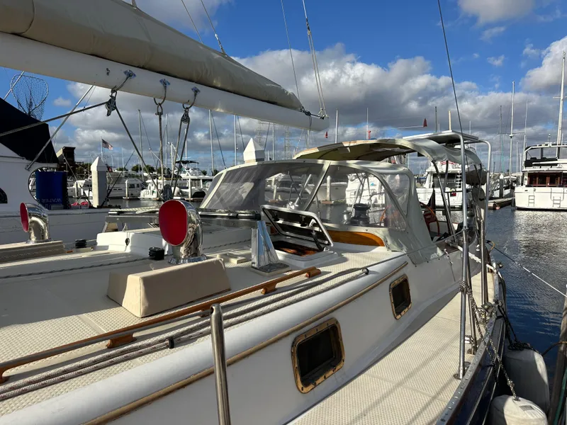 Slide: The Image of 1985 Shannon 43 Classic Cutter sailboat docked in a marina under a blue sky. - 18
