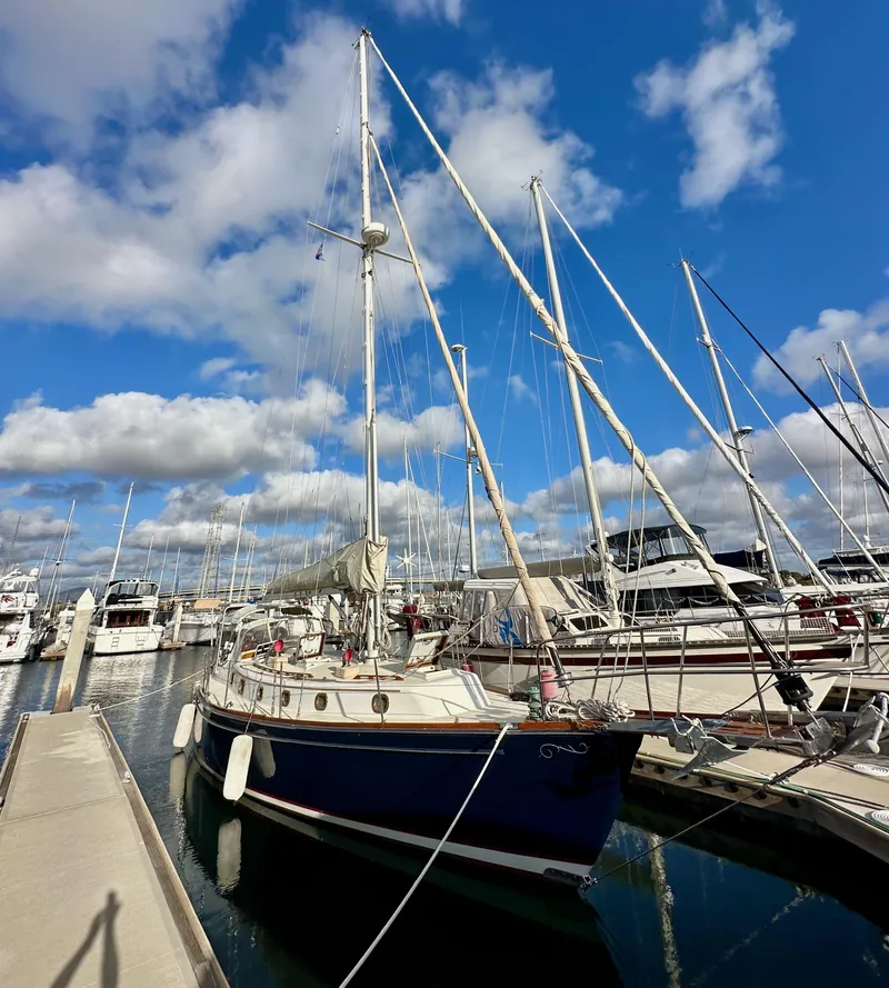 Slide: The Image of 1985 Shannon 43 Classic Cutter sailboat docked at marina under blue sky. - 3