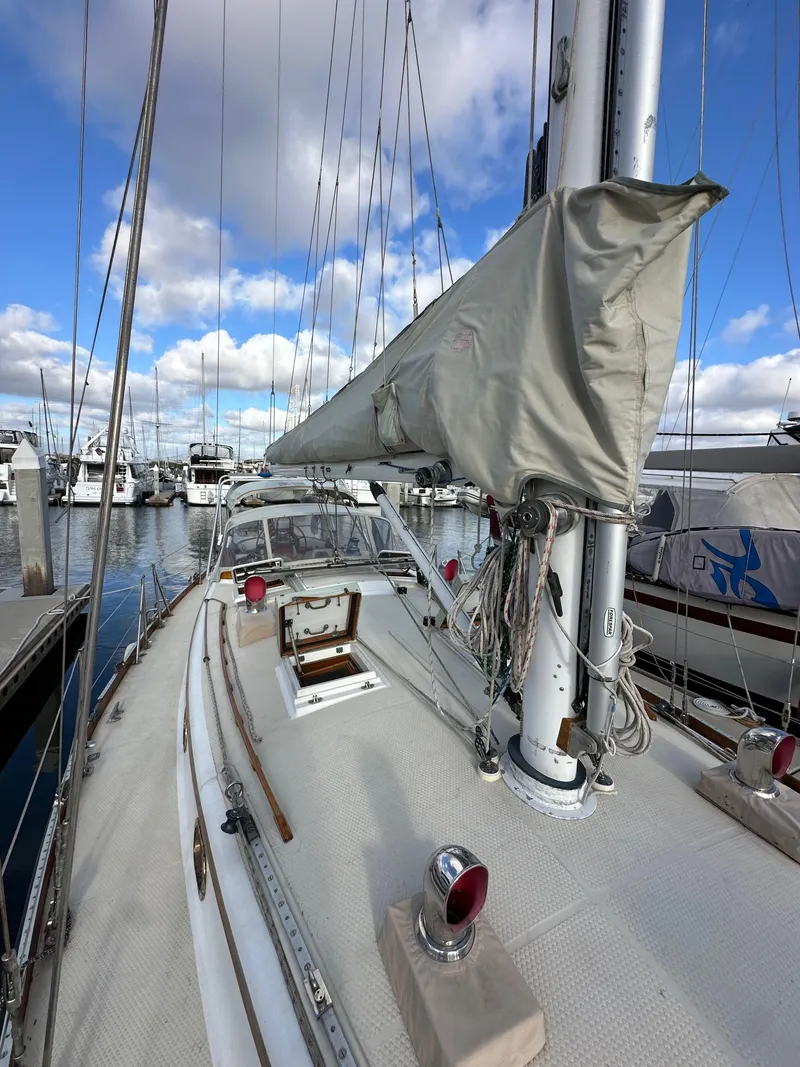 Slide: The Image of 1985 Shannon 43 Classic Cutter sailboat docked at marina, cloudy sky background. - 32