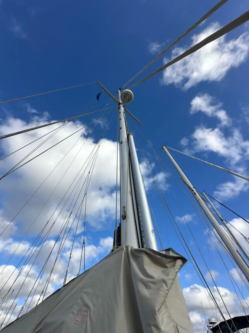 Slide: The Image of Mast of 1985 Shannon 43 Classic Cutter sailboat against a blue sky with clouds. - 33