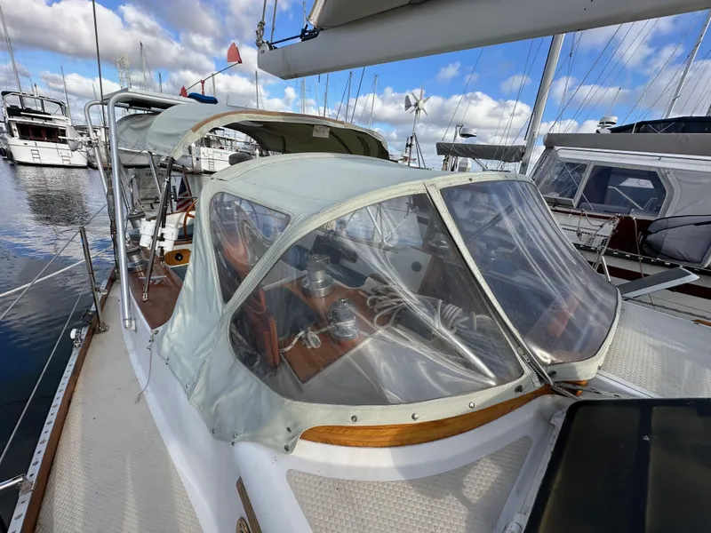 Slide: The Image of 1985 Shannon 43 Classic Cutter sailboat with protective canopy, docked at marina. - 35