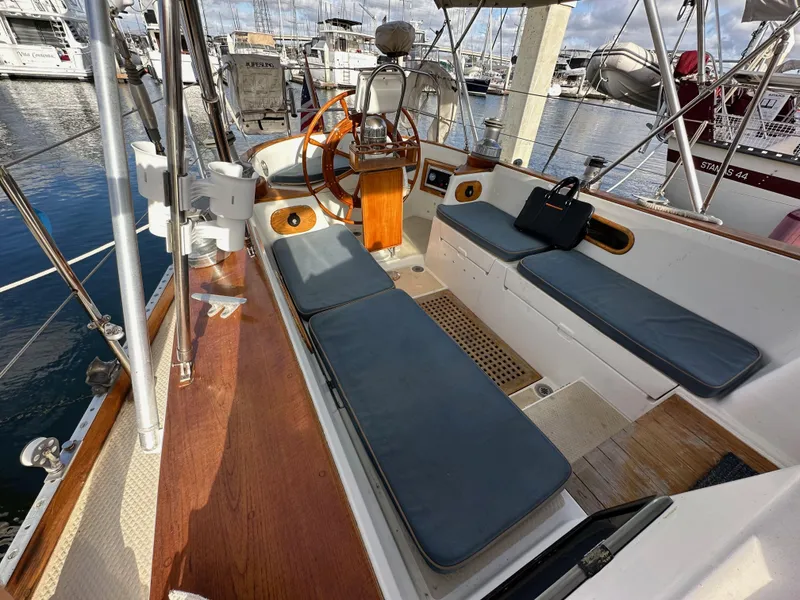 Slide: The Image of 1985 Shannon 43 Classic Cutter sailboat cockpit with cushioned seating and wooden steering wheel. - 37