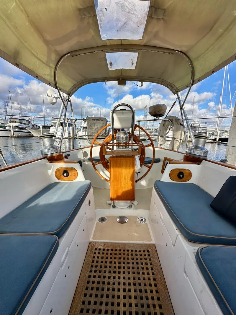 Slide: The Image of 1985 Shannon 43 Classic Cutter sailboat cockpit with wooden wheel and blue cushions. - 38