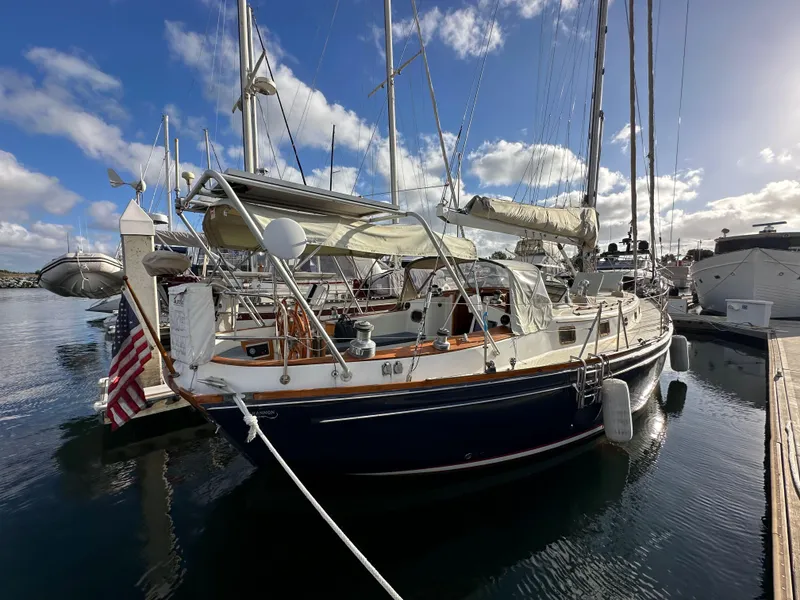 Slide: The Image of 1985 Shannon 43 Classic Cutter sailboat docked in a marina under a blue sky. - 6