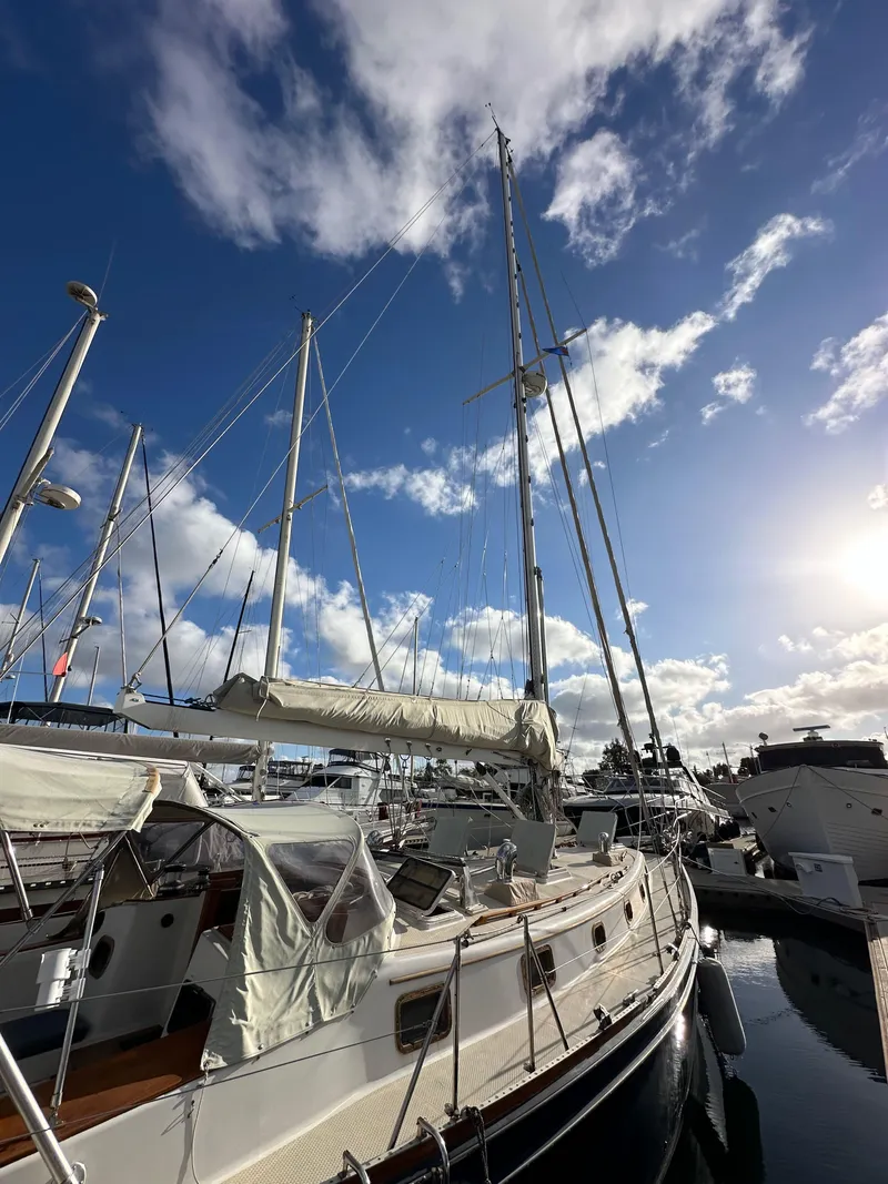 Slide: The Image of 1985 Shannon 43 Classic Cutter sailboat docked under a bright blue sky. - 7