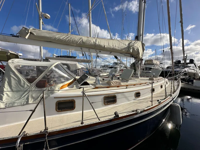 Slide: The Image of 1985 Shannon 43 Classic Cutter sailboat docked in marina under blue sky. - 8