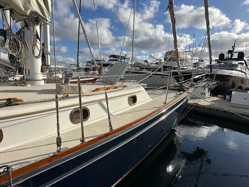 Slide: The Image of 1985 Shannon 43 Classic Cutter sailboat docked at marina under blue sky. - 9