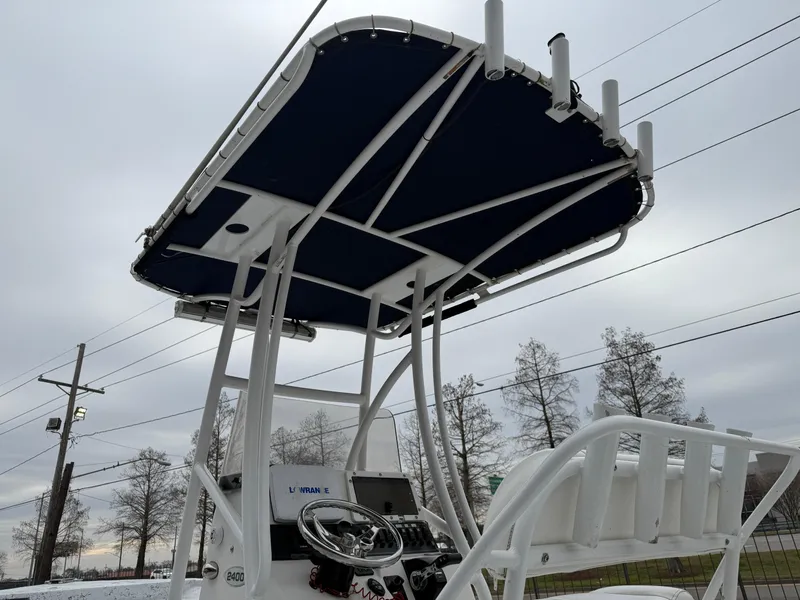 Slide: The Image of 2012 Blazer 2400 boat with T-top and steering console, under cloudy sky. - 11