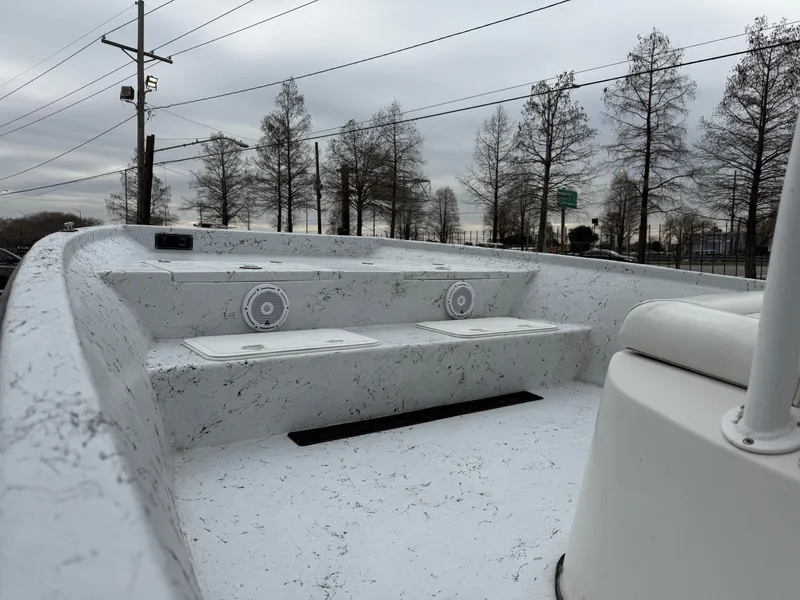 Slide: The Image of 2012 Blazer 2400 boat interior with white-speckled design, featuring seating and speakers. - 12