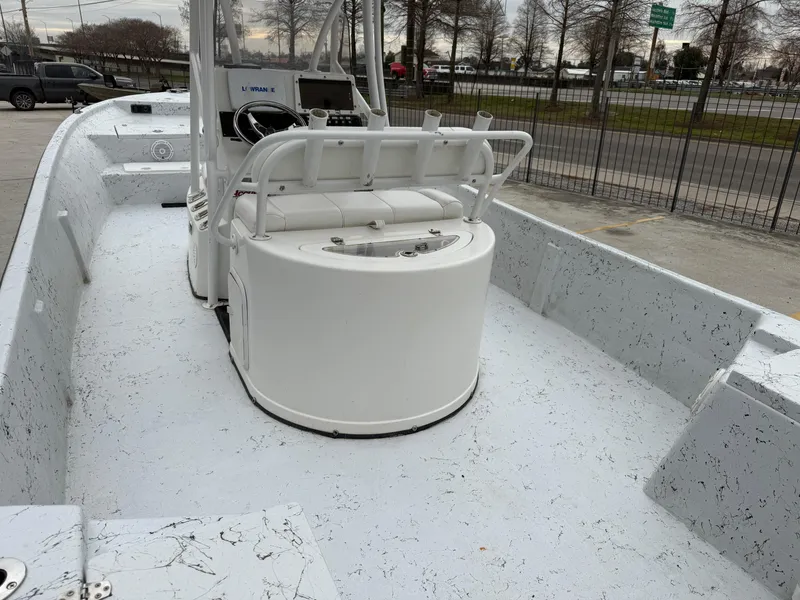 Slide: The Image of 2012 Blazer 2400 boat interior with console and seating, parked near a road. - 13